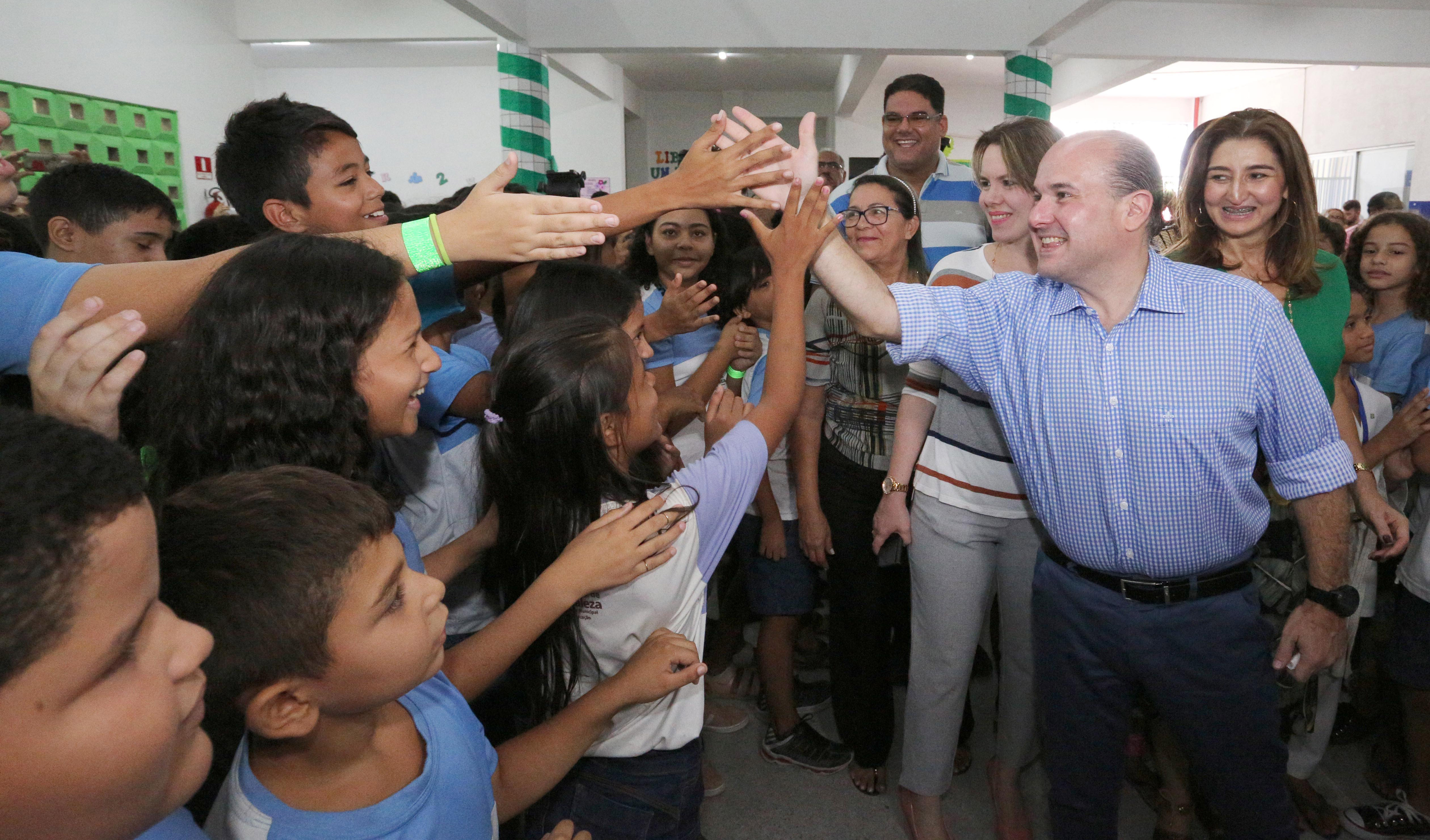 prefeito roberto cláudio cumprimenta alunos em uma escola